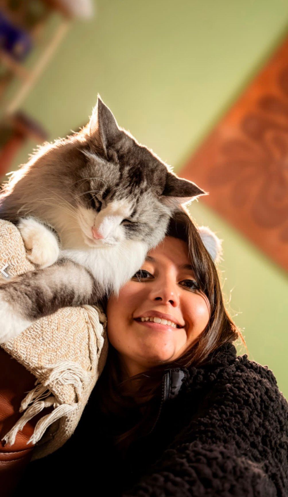 Sofia cuddling a fluffy grey and white cat