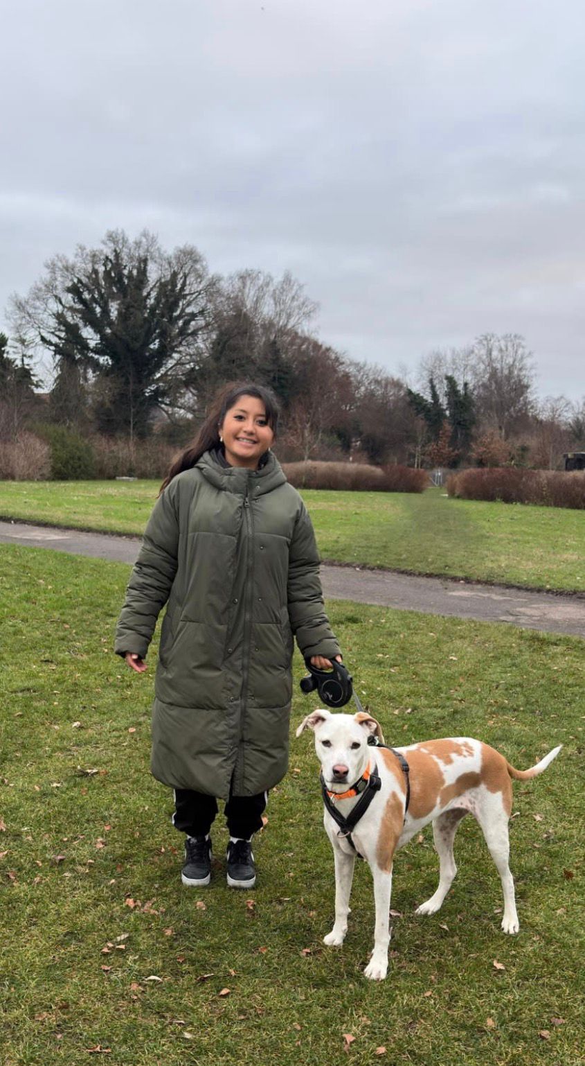 Sofia walking a dog in the park on a winter day